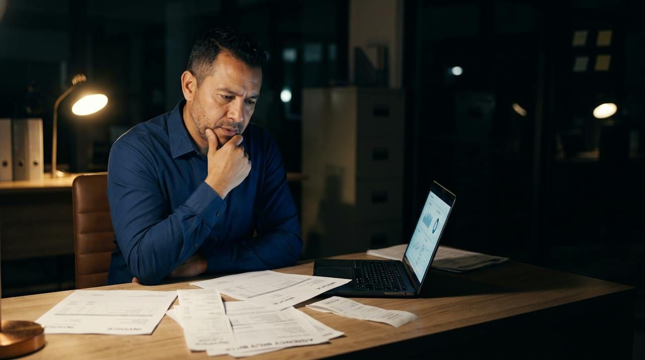 Owner reviewing marketing invoices late at night